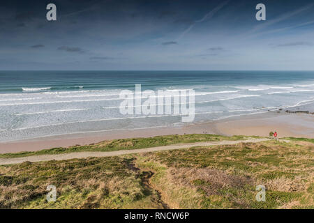 Ein paar stehend auf dem South West Coast Path, die über Watergate Bay in North Cornwall. Stockfoto