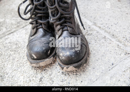 Schlammig und schmutzig schwarzen Stiefeln Tag nach Metal Musik Festival Stockfoto