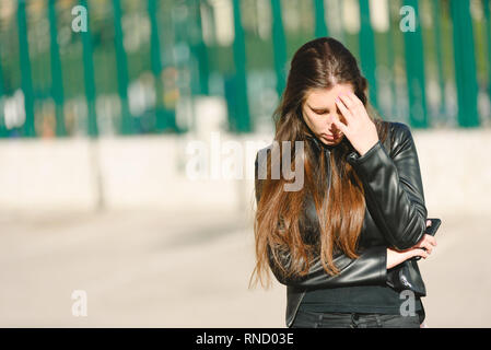 Traurig jugendlich Mädchen tausendjährigen Frau Gefühl untröstlich am Telefon, deprimiert umgekippt durch schlechte Nachrichten in mobilen Angstgefühle. Stockfoto