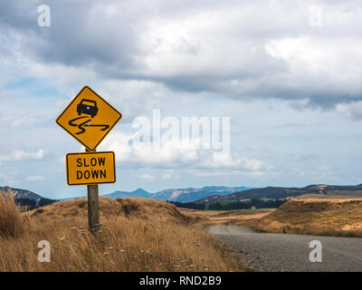 Slow Down Warnung Schild, nicht abgeschottete Schotterstraße, Ngamatea Station, Inland Mokai Patea, Central North Island, Neuseeland Stockfoto