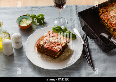 Vegane Lasagne mit Linsen und Erbsen in einem Blech auf einem Tisch mit einem blauen Leinen Tischdecke. gesunde italienische Küche für die ganze Familie, Par Stockfoto