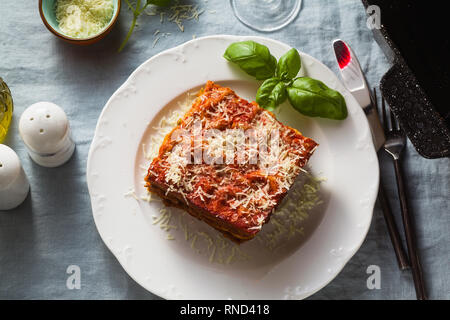 Vegane Lasagne mit Linsen und Erbsen in einem Blech auf einem Tisch mit einem blauen Leinen Tischdecke. gesunde italienische Küche für die ganze Familie, Par Stockfoto