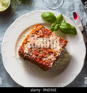 Vegane Lasagne mit Linsen und Erbsen in einem Blech auf einem Tisch mit einem blauen Leinen Tischdecke. gesunde italienische Küche für die ganze Familie, Par Stockfoto