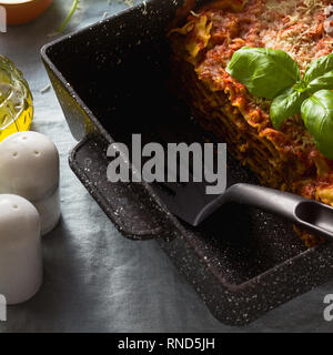 Vegane Lasagne mit Linsen und Erbsen in einem Blech auf einem Tisch mit einem blauen Leinen Tischdecke. gesunde italienische Küche für die ganze Familie, Par Stockfoto