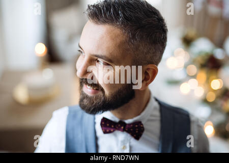 Ein Porträt von einem reifen Mann, der Zuhause auf einer Party, weg schauen. Stockfoto