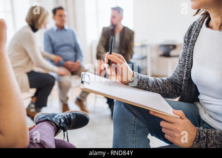 Ein Mittelteil der Ratgeber mit Zwischenablage in einem Gespräch mit einem Kunden während der Therapie. Stockfoto