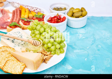 Italienische Antipasti Wein Snacks. Antipasto catering Plattenteller mit ruckartiger, Salami, Käse, Trauben, Oliven, Gurken, Schinken, Melone, Brushettas. Ital Stockfoto
