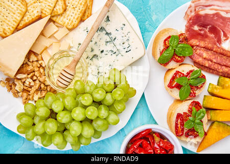 Italienische Antipasti Wein Snacks. Antipasto catering Plattenteller mit ruckartiger, Salami, Käse, Trauben, Oliven, Gurken, Schinken, Melone, Brushettas. Ital Stockfoto