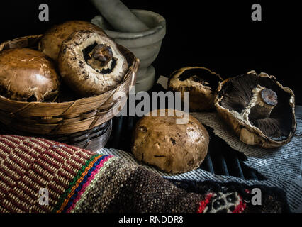Korb mit frischen Pilzen dunkle Fotografie Stockfoto