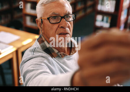 Dozent Unterricht in Klasse an die Tafel schreiben. Porträt eines Senior Professor in der Klasse unterrichten. Stockfoto