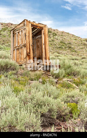 Eine verlassene Plumpsklo auf einem Hügel in Bodie Ghost Town, Kalifornien. Stockfoto