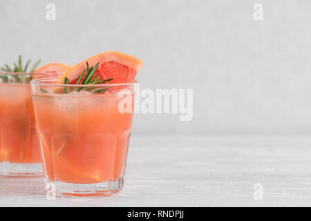 Zwei Gläser mit frischen Grapefruit Sommer Alkohol Cocktail, Eis und Rosmarin auf weißem Hintergrund. Nach oben Schließen Stockfoto