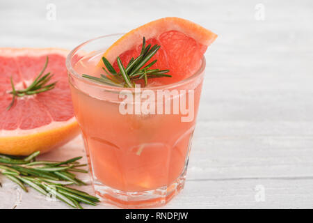 Glas mit frischem Grapefruitsaft Sommer Alkohol Cocktail, Eis und Rosmarin auf weißem Hintergrund. Nach oben Schließen Stockfoto