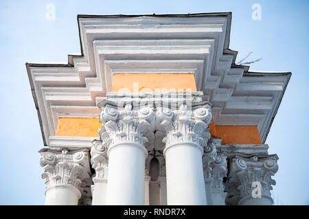 Weiße Säulen mit gelben Portikus unter blauem Himmel, klassische Architektur Stockfoto