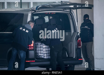 Frankfurt am Main, Deutschland. 18 Feb, 2019. Die Mitarbeiter der Zentralen Ausländerbehörde (ZAB), die das Gepäck von einer Abschiebung Gefangener im Terminal 2 des Flughafens entladen werden mit Sturm Hauben maskiert. Foto: Boris Roessler/dpa Quelle: dpa Picture alliance/Alamy leben Nachrichten Stockfoto