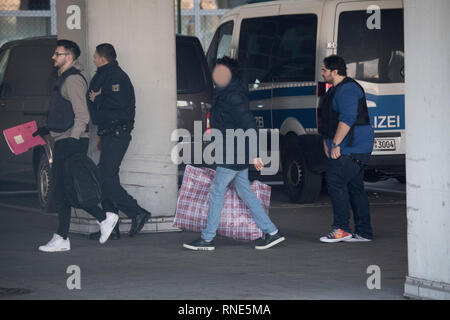 Frankfurt am Main, Deutschland. 18 Feb, 2019. Polizisten begleiten ein Mann (M) zu einem Terminal am Flughafen, von wo aus er nach Afghanistan mit einem gecharterten Flugzeug am Abend abgeschoben werden. Foto: Boris Roessler/dpa - ACHTUNG: Die Person pixelated wurde aus Gründen der Persönlichkeitsrechte Quelle: dpa Picture alliance/Alamy leben Nachrichten Stockfoto