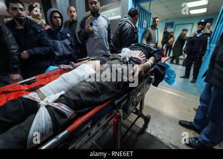 Gaza, Palästina. 18 Feb, 2019. Eine verletzte Demonstrator liegen auf einer Bahre gesehen ins Krankenhaus gebracht werden Behandlung während der Auseinandersetzungen zu erhalten. palästinensische Demonstranten, die sich selbst die "Nacht der Verwirrung Einheiten'' in Brand gesetzt, wie sie in der Nähe der Gaza-Israel Grenze östlich von zentralen Gazastreifen sammeln. Die so genannte "Nacht der Verwirrung Einheiten'' auch mit israelischen Truppen entlang des Sicherheitszauns zusammengestoßen, nach etwa zwei Monaten ohne solche nächtlichen Scharmützel. Credit: Mohamed Zarandah/SOPA Images/ZUMA Draht/Alamy leben Nachrichten Stockfoto