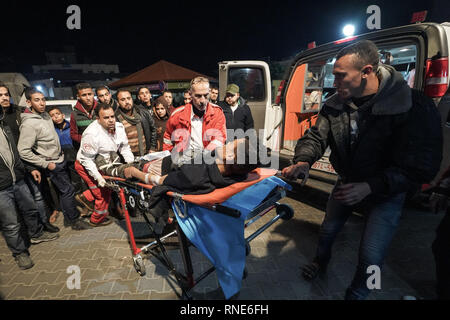 Gaza, Palästina. 18 Feb, 2019. Eine verletzte Demonstrator liegen auf einer Bahre gesehen ins Krankenhaus gebracht werden Behandlung während der Auseinandersetzungen zu erhalten. palästinensische Demonstranten, die sich selbst die "Nacht der Verwirrung Einheiten'' in Brand gesetzt, wie sie in der Nähe der Gaza-Israel Grenze östlich von zentralen Gazastreifen sammeln. Die so genannte "Nacht der Verwirrung Einheiten'' auch mit israelischen Truppen entlang des Sicherheitszauns zusammengestoßen, nach etwa zwei Monaten ohne solche nächtlichen Scharmützel. Credit: Mohamed Zarandah/SOPA Images/ZUMA Draht/Alamy leben Nachrichten Stockfoto