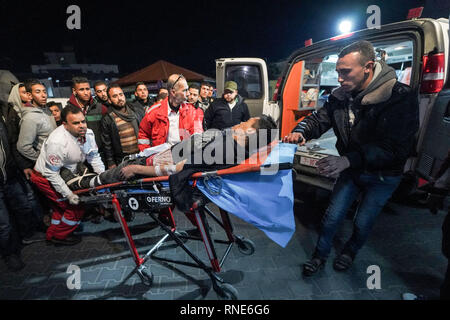 Gaza, Palästina. 18 Feb, 2019. Eine verletzte Demonstrator liegen auf einer Bahre gesehen ins Krankenhaus gebracht werden Behandlung während der Auseinandersetzungen zu erhalten. palästinensische Demonstranten, die sich selbst die "Nacht der Verwirrung Einheiten'' in Brand gesetzt, wie sie in der Nähe der Gaza-Israel Grenze östlich von zentralen Gazastreifen sammeln. Die so genannte "Nacht der Verwirrung Einheiten'' auch mit israelischen Truppen entlang des Sicherheitszauns zusammengestoßen, nach etwa zwei Monaten ohne solche nächtlichen Scharmützel. Credit: Mohamed Zarandah/SOPA Images/ZUMA Draht/Alamy leben Nachrichten Stockfoto