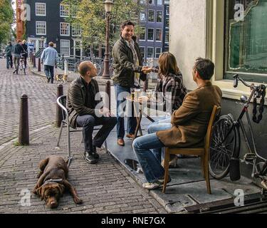 Amsterdam, Niederlande. 9. Okt. 2005. Mit ihrem Hund, eine Gruppe von Menschen bei einem Getränk an einem outdoor Café in Amsterdam, Niederlande. Credit: Arnold Drapkin/ZUMA Draht/Alamy leben Nachrichten Stockfoto