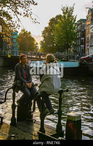 Amsterdam, Niederlande. 9. Okt. 2005. Zwei junge Frauen sitzen durch einen Kanal in Amsterdam, Niederlande. Credit: Arnold Drapkin/ZUMA Draht/Alamy leben Nachrichten Stockfoto