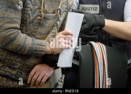 Stuttgart, Deutschland. 19 Feb, 2019. Die Beklagte (l) in der Studie von zwei angeblichen Kriegsverbrechen in der Syrischen Konflikt ist an seinen Ort in einem Gerichtssaal des Oberlandesgericht Stuttgart übernommen. Als Mitglied der "Freien Syrischen Armee (FSA)", sagte der Angeklagte ist eingesperrt und gefoltert zu haben, zwei Personen mit Mitstreiter in der Provinz Idlib. Credit: Marijan Murat/dpa/Alamy leben Nachrichten Stockfoto