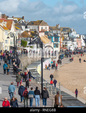 Lyme Regis, Dorset, Großbritannien. 19. Februar 2019. UK Wetter: Familien und Urlauber strömen zu den Strand in der malerischen Küstenstadt Lyme Regis über die Schule half term Break zu einem Spaziergang am Strand an einem Tag des ungewöhnlich hellen Sonnenschein und blauer Himmel genießen. Credit: Celia McMahon/Alamy leben Nachrichten Stockfoto