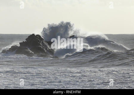 Stürmischen Meer Wellen, die über die Klippen aus dem nördlichen portugiesischen Küste. Weiche mit Hintergrundbeleuchtung. Stockfoto