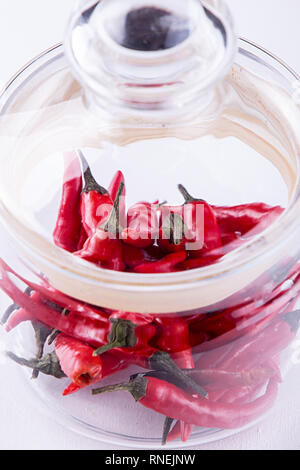 Rote kleine spisy chili peppers in Glas. Stockfoto