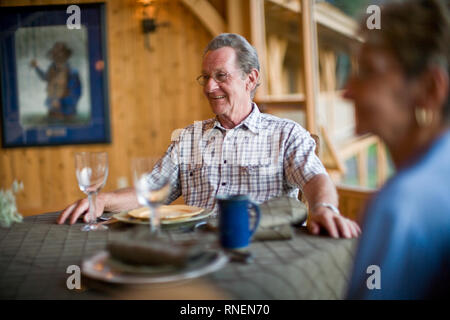 Älteres Ehepaar am Tisch sitzen Stockfoto