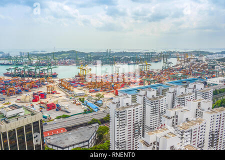 Luftaufnahme von Singapur Gütertransporte Port mit Fracht Krane und transportational Container, städtische Umgebung mit modernen Gebäuden im Vordergrund Stockfoto