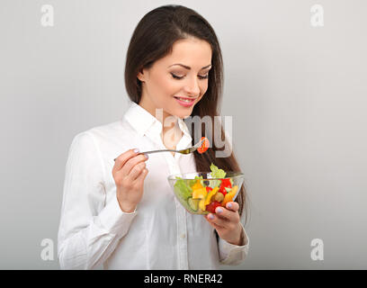 Schönen Lächeln, Geschäftsfrau gesund essen Bio vegatable Salat auf das Mittagessen auf blauem Hintergrund mit der leere Raum. Gesunde Ernährung am Arbeitsplatz ti Stockfoto