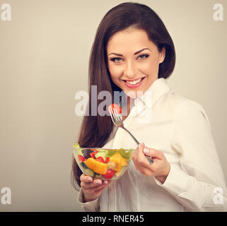 Schönen Lächeln, Geschäftsfrau gesund essen Bio vegatable Salat auf das Mittagessen auf blauem Hintergrund mit der leere Raum. Gesunde Ernährung am Arbeitsplatz ti Stockfoto