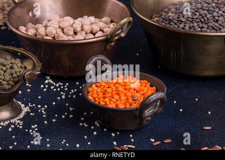 Verschiedenen Hülsenfrüchten beens in Vintage cooper Schalen. Rote und grüne Linsen, mash Mung Bohnen, Kichererbsen auf dunklem Hintergrund Stockfoto