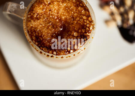 Makro Foto des heißen Latte mit caramel Kruste gebacken. Essen Konzept. Ansicht von oben Schließen Sie herauf Bild von Kaffee. Stockfoto