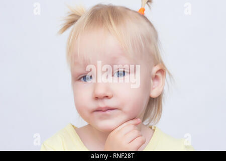 Porträt eines kleinen Business girl blond mit blauen Augen und Pigtails auf einem weißen Hintergrund, Nahaufnahme, emotionale, kaukasische Stockfoto