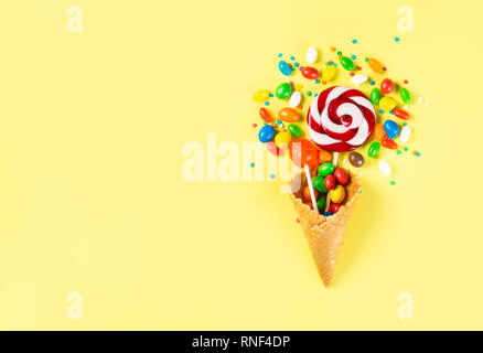 Lollopops und Bonbons in Eis auf gelben Hintergrund Stockfoto