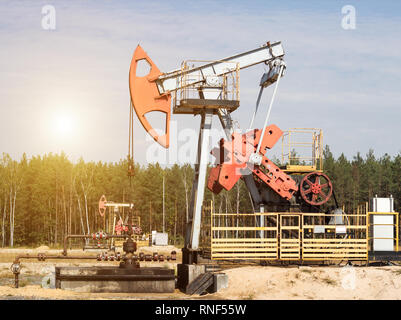 Öl für die Produktion von Öl und Benzin und Erdgas auf dem Hintergrund der Wald, die Produktion von Benzin, pumpjack, Gewinnung von Erdöl Stockfoto