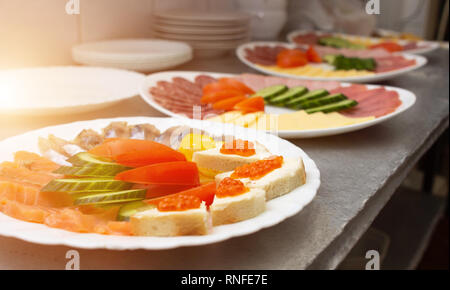 Auf einem Schild in Form von Wurst, Schinken und Gemüse geschnitten, Sandwiches mit rotem Kaviar Stockfoto