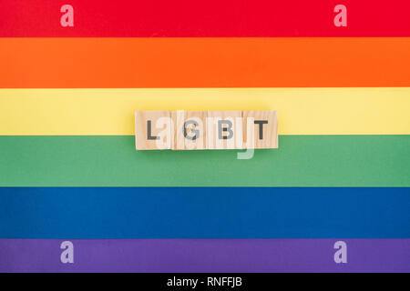 Blick von oben auf die Lgbt-gemacht-Schriftzug Holzklötze auf Papier Regenbogen Hintergrund Stockfoto