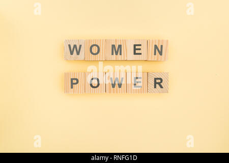 Blick von oben auf die Frauen Power Schriftzug von Holzwürfeln auf gelbem Hintergrund Stockfoto