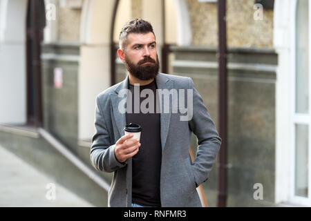 Man bärtige hipster Pappbecher Kaffee trinken. Noch ein Schluck Kaffee. Kaffee trinken für Unterwegs. Geschäftsmann lumbersexual Erscheinungsbild genießen Sie Kaffee Pause aus Business Center. Entspannen und erholen Sie sich. Stockfoto