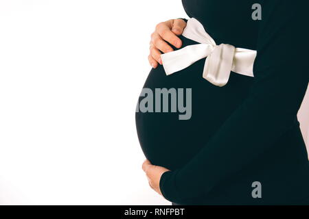 Schwangere Frau in schwarzem Kleid Holding Bauch Closeup Stockfoto