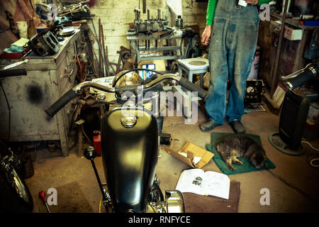 Innenansicht der lokalen Motorrad Werkstatt Garage voll von verschiedenen Motorräder und Ersatzteile in Reparatur Stockfoto