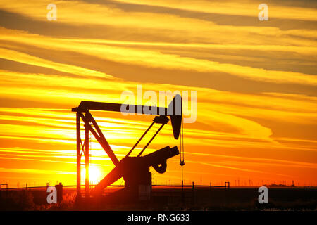 Silhouetted Pumpe Jack im Ölfeld bei Sonnenuntergang Stockfoto