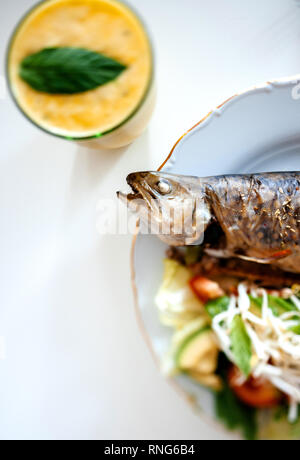 Blick von oben der leckeren warmen Forellen fischen mit Bio Salat und Glas Limonade mit mint Blatt Stockfoto