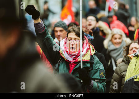 Straßburg, Frankreich - Mar 22, 2018: Junge Frau mit Arretierhebel-sicherung holding CGT Allgemeiner Verband der Arbeit Flagge mit anderen Arbeitern Plakate an der Demonstration Protest gegen Längestrich französische Regierung string der Reformen Stockfoto