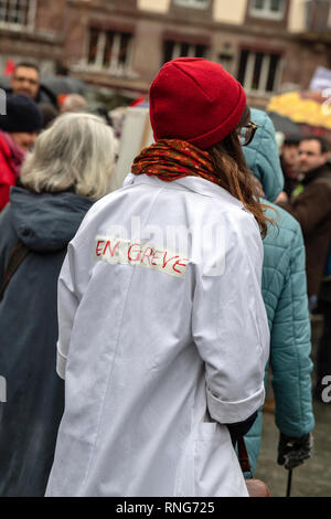 Straßburg, Frankreich - Mar 22, 2018: die Menschen, die sich in Place Kleber Platz während der CGT Allgemeiner Verband der Arbeit demonstration Protest gegen Längestrich französische Regierung string der Reformen - Rückansicht der jungen Krankenschwester im weißen Mantel Stockfoto