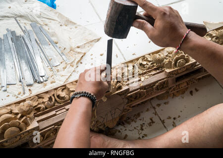 Die Hände eines Zimmermanns die traditionelle Holzschnitzerei in Bali, Indonesien. Lokale handwerkliche Tradition Konzept Stockfoto