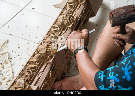 Die Hände eines Zimmermanns die traditionelle Holzschnitzerei in Bali, Indonesien. Lokale handwerkliche Tradition Konzept Stockfoto